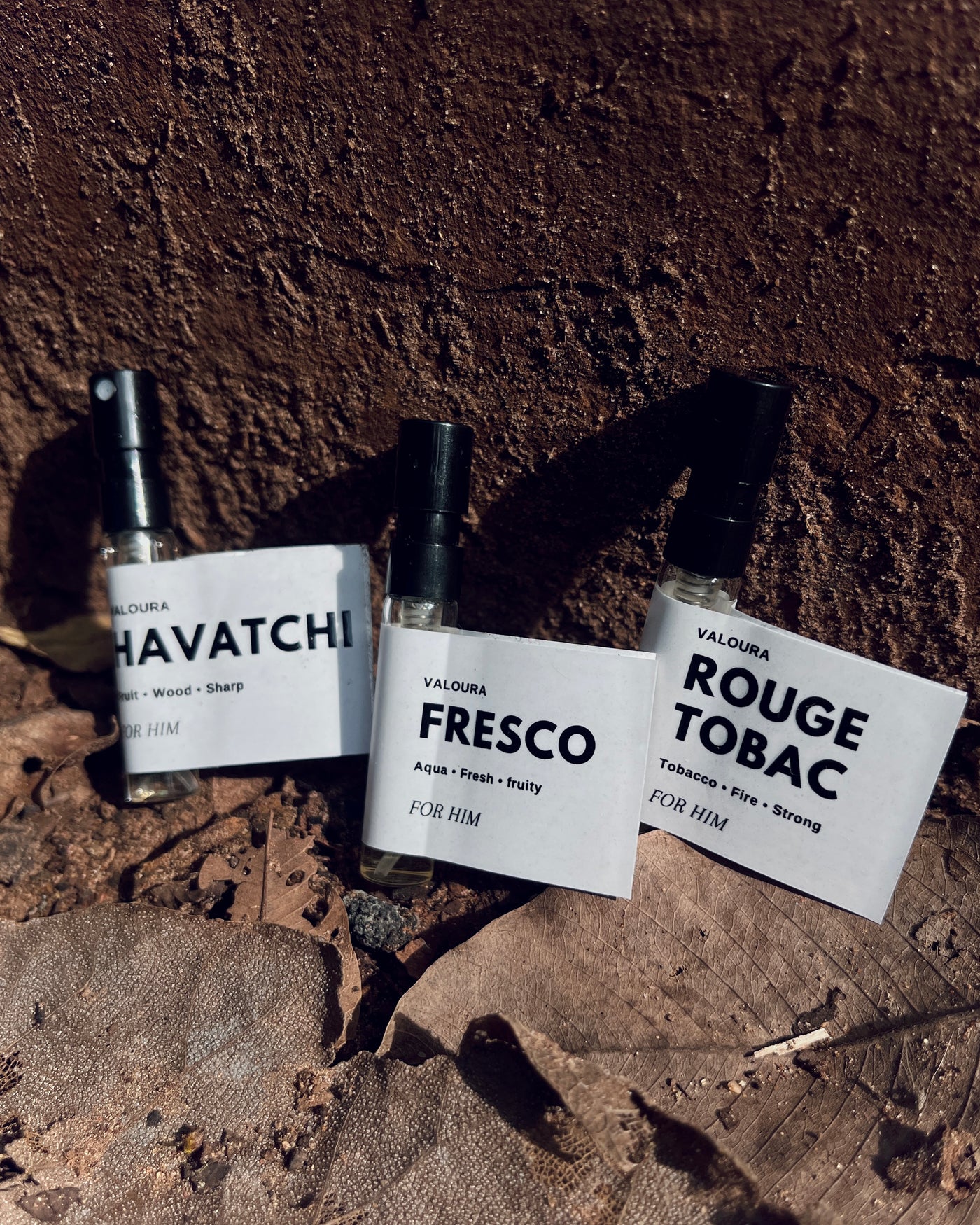 Three perfume vails labeled 'Havatchi', 'Fresco', and 'Rouge Tobac' on a textured surface.