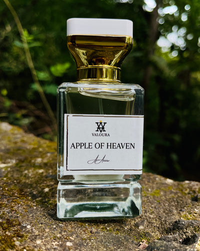Perfume bottle labeled 'Apple of Heaven' by Valoura on a stone surface with a blurred natural background