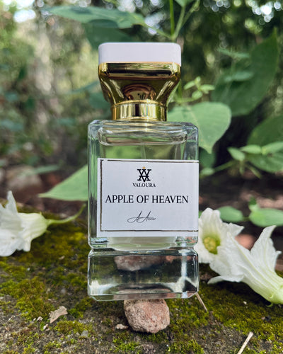 Valoura Apple of Heaven perfume bottle with gold cap on a natural background with jasmine flower near 