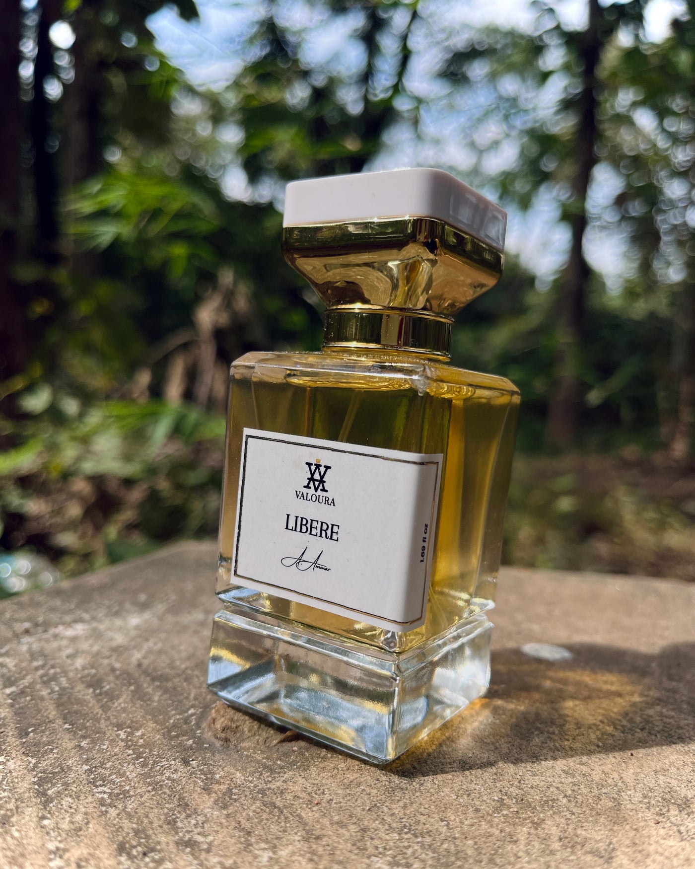 Perfume bottle labeled 'Libère' by Valhéria on a stone surface with a blurred natural background
