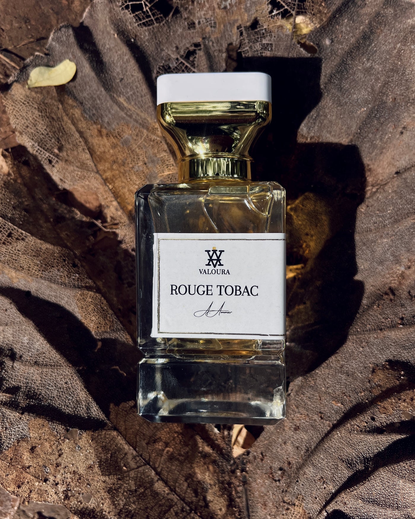 Valoura  Rouge Tobac perfume bottle on a textured brown leaf  background 