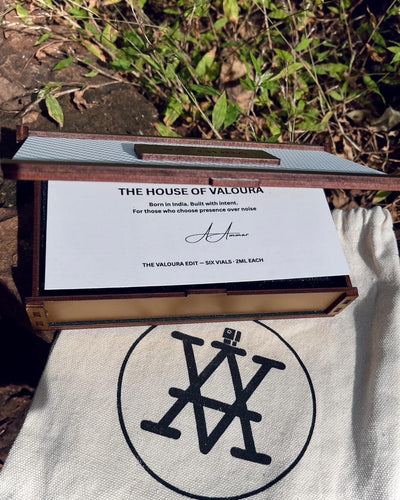 Wooden box with a white label featuring 'The House of Valoura' branding, placed on a fabric surface with a natural background.